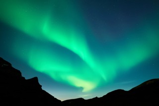 Night starry sky with green Aurora borealis Northern lights